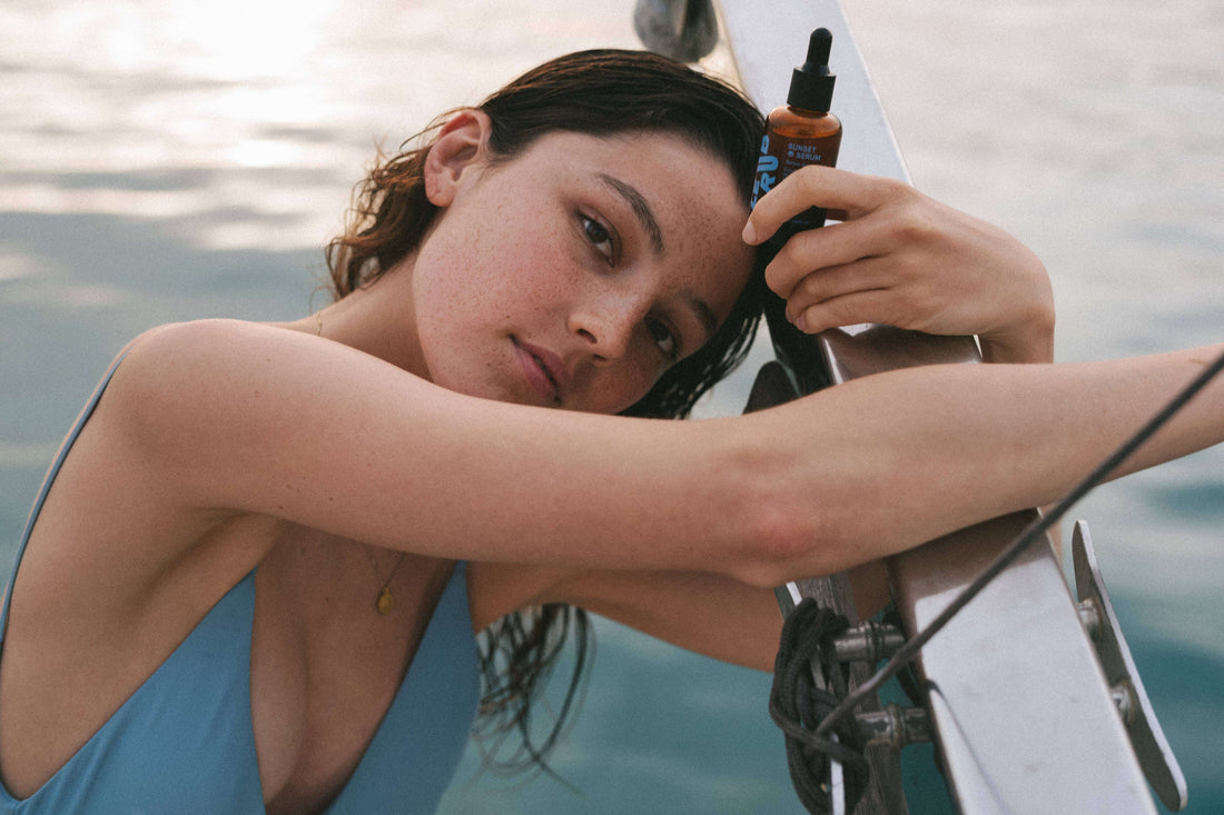 Girl Holding Le Rub Sunset Serum On a Boat